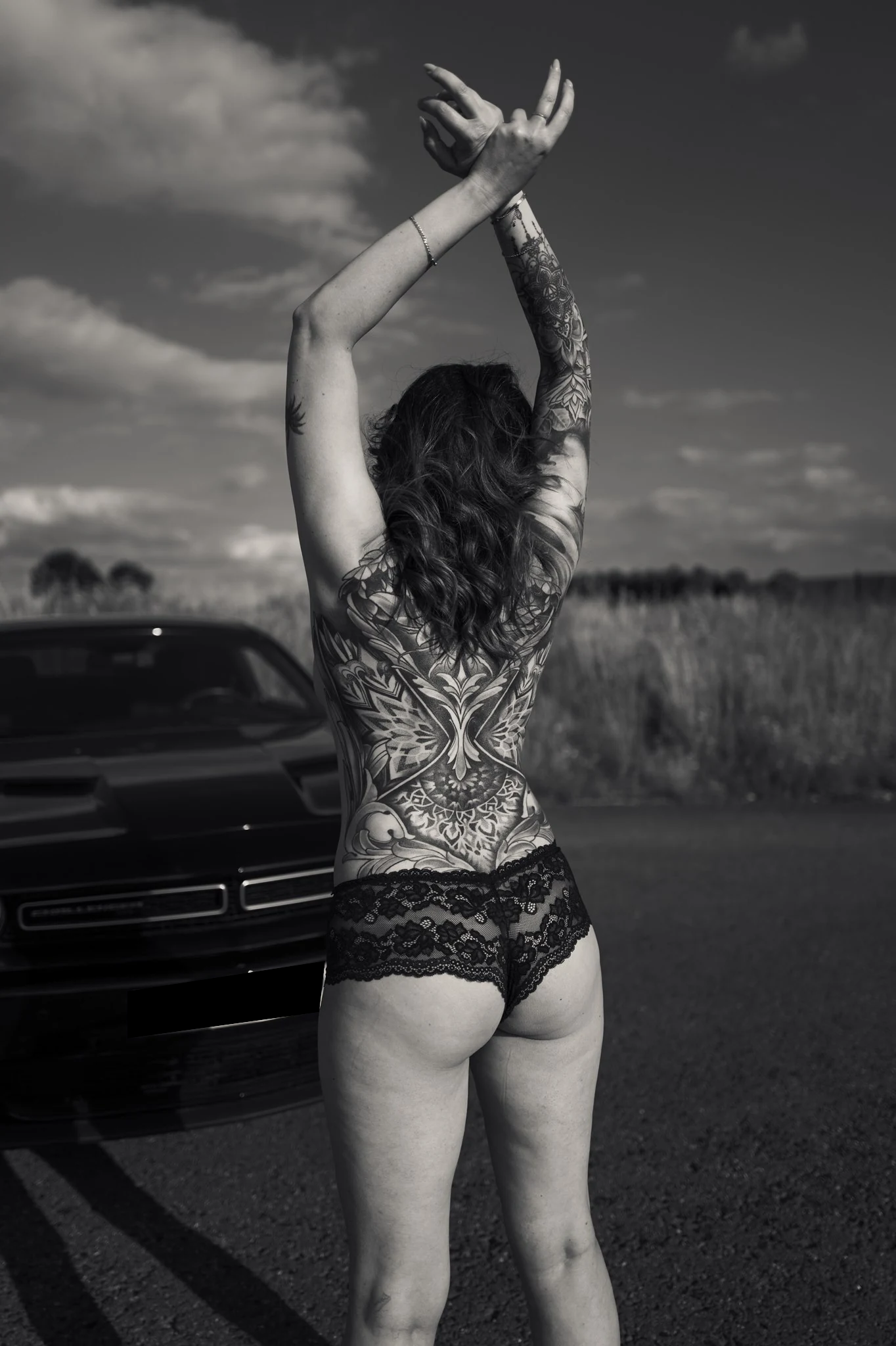 Julia vor dem Auto mit erhobenen Armen