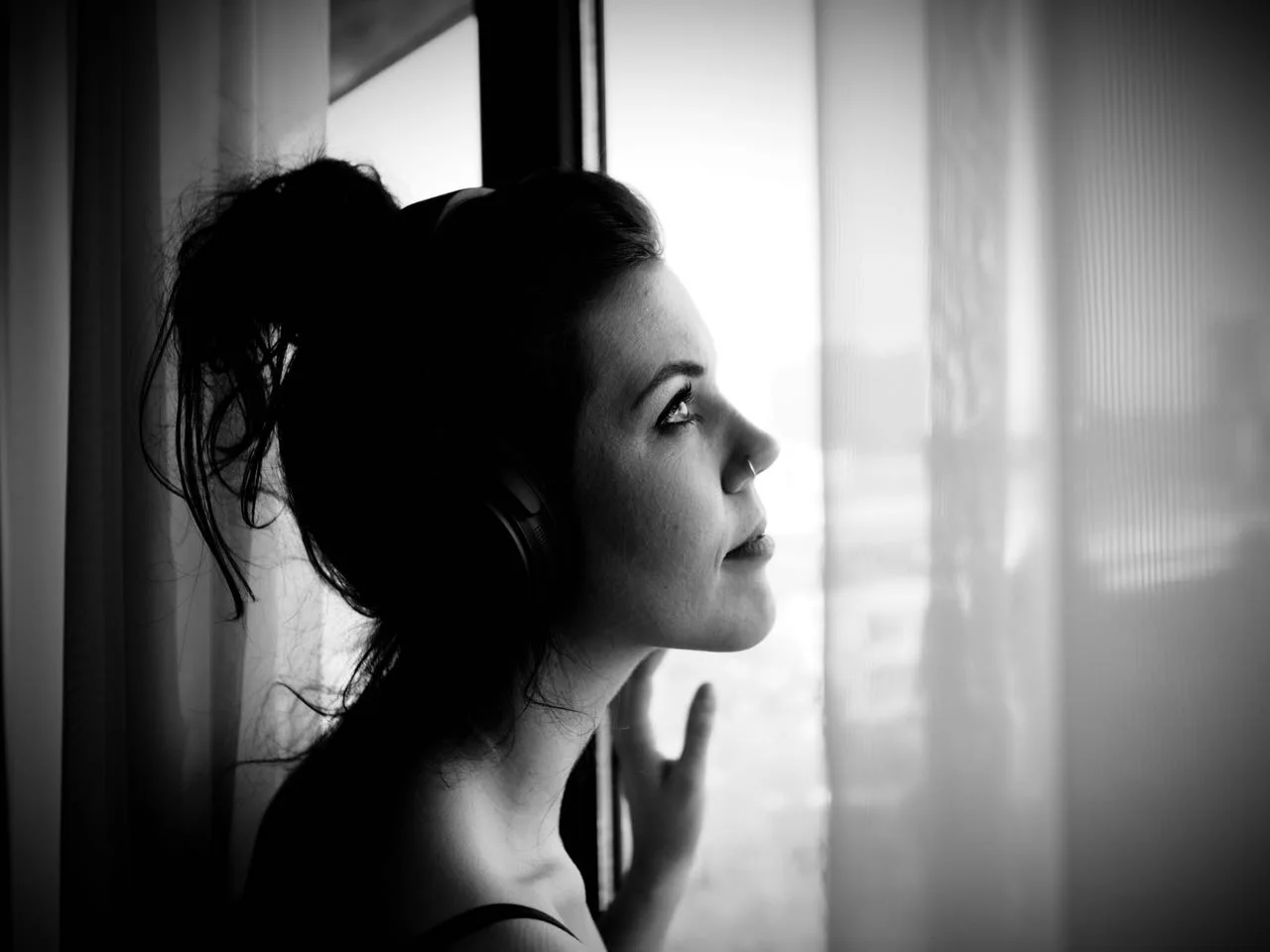 Mit Kopfhörern am Fenster: ein Moment beim ersten Boudoir-Shooting.